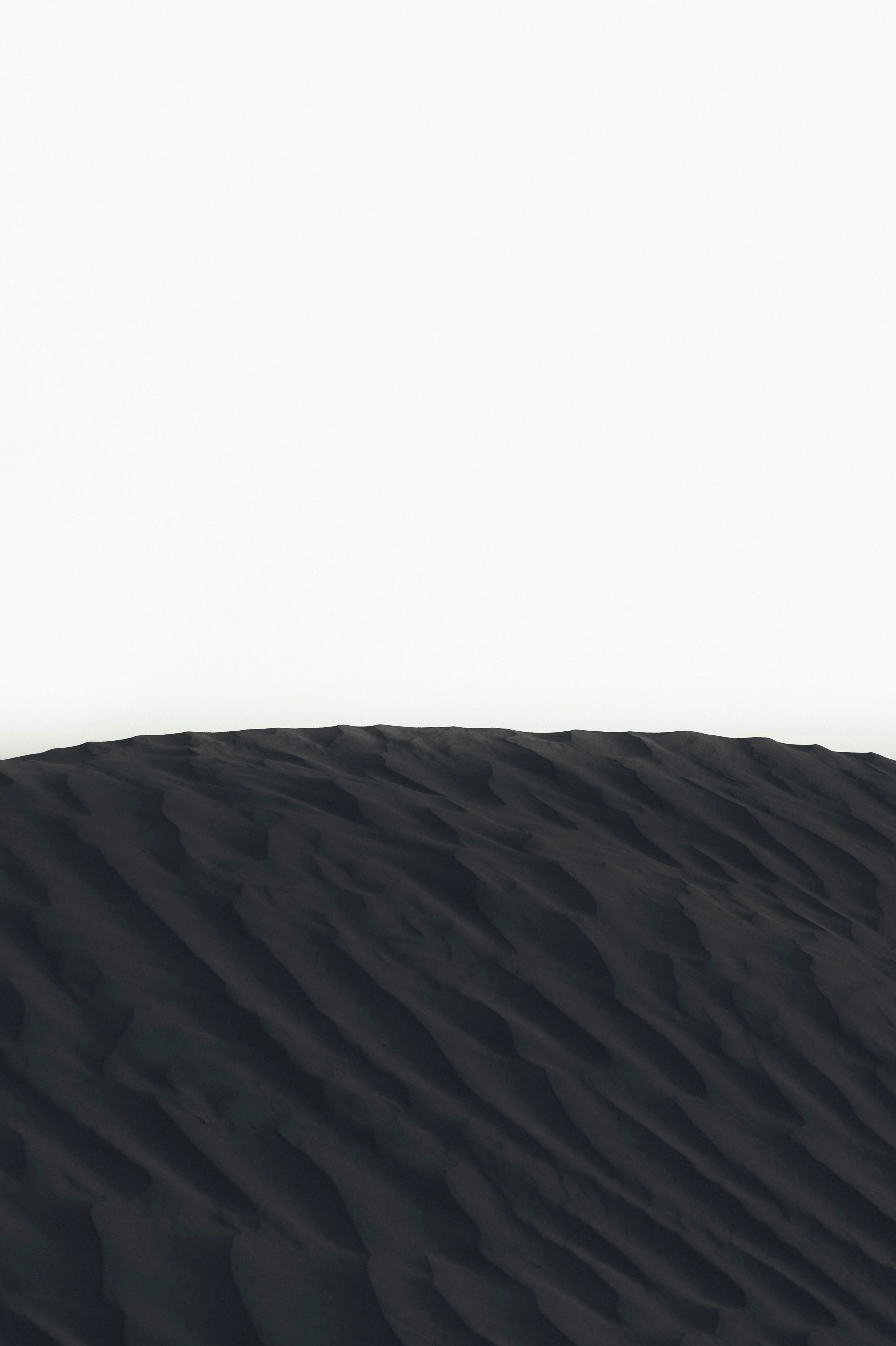 black sand against a white horizon